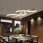 Gold music note LED pendant chandelier hanging above a dark wood dining table in a modern luxury dining room