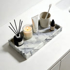 Marble tray styled on bathroom counter with candle, diffuser, and skincare products