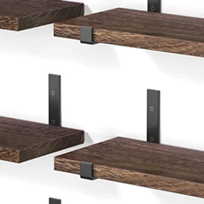 Close-up detail of dark walnut wood grain texture and matte black metal bracket hardware on floating wall shelves