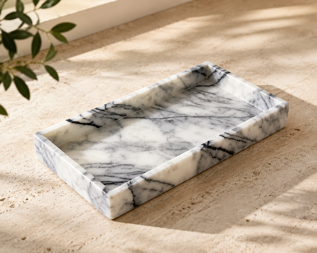 Marble tray on sandy surface with natural light and olive branch